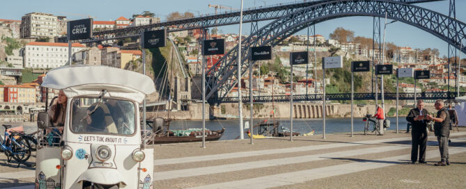 Tuk Tuk elétrico junto à Ponte Dom Luís I, ideal para descobrir o Porto num tour de 1 dia