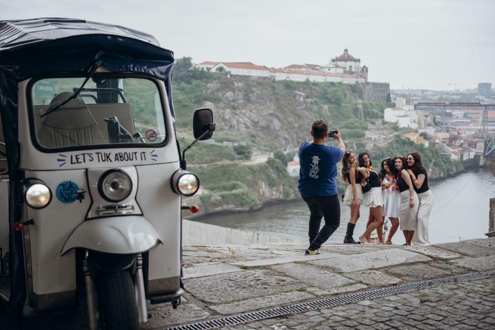 Group of friends having fun during a Tuk Tuk tour in Porto