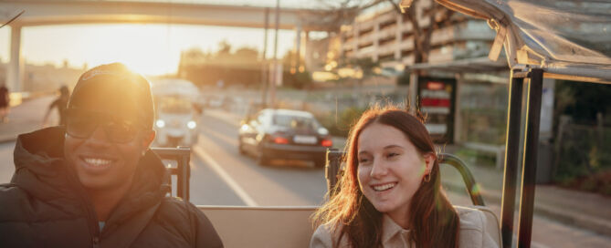 Casal a desfrutar do pôr do sol durante um tour de Tuk Tuk no Porto